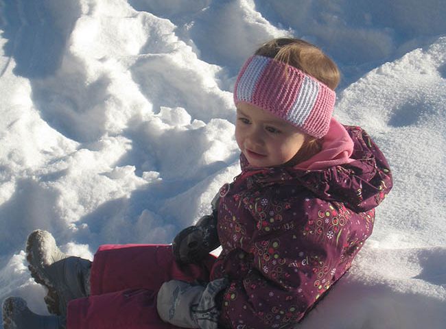 Kind sitzt im Schnee